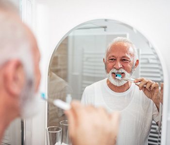 a man brushing per dental implant post-op instructions