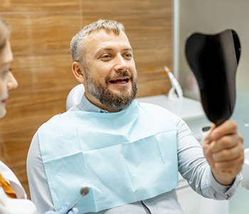 a patient checking his new dental implant restorations