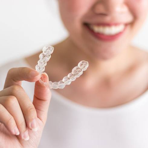 person holding an Invisalign clear aligner in Brecksville 
