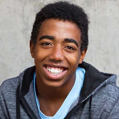 Young man with healthy smile after wisdom tooth extraction