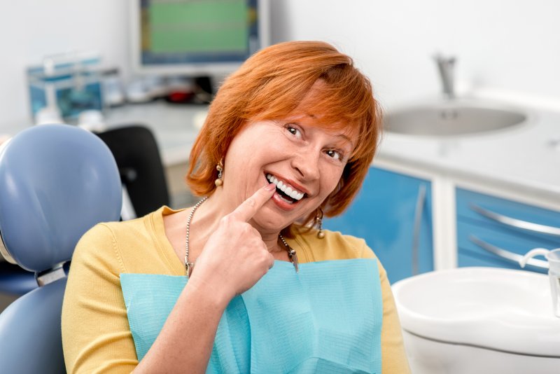 Red-haired woman proudly pointing to new implant