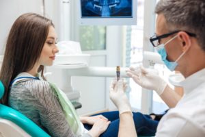 a dentist answering a patient’s questions about dental implants